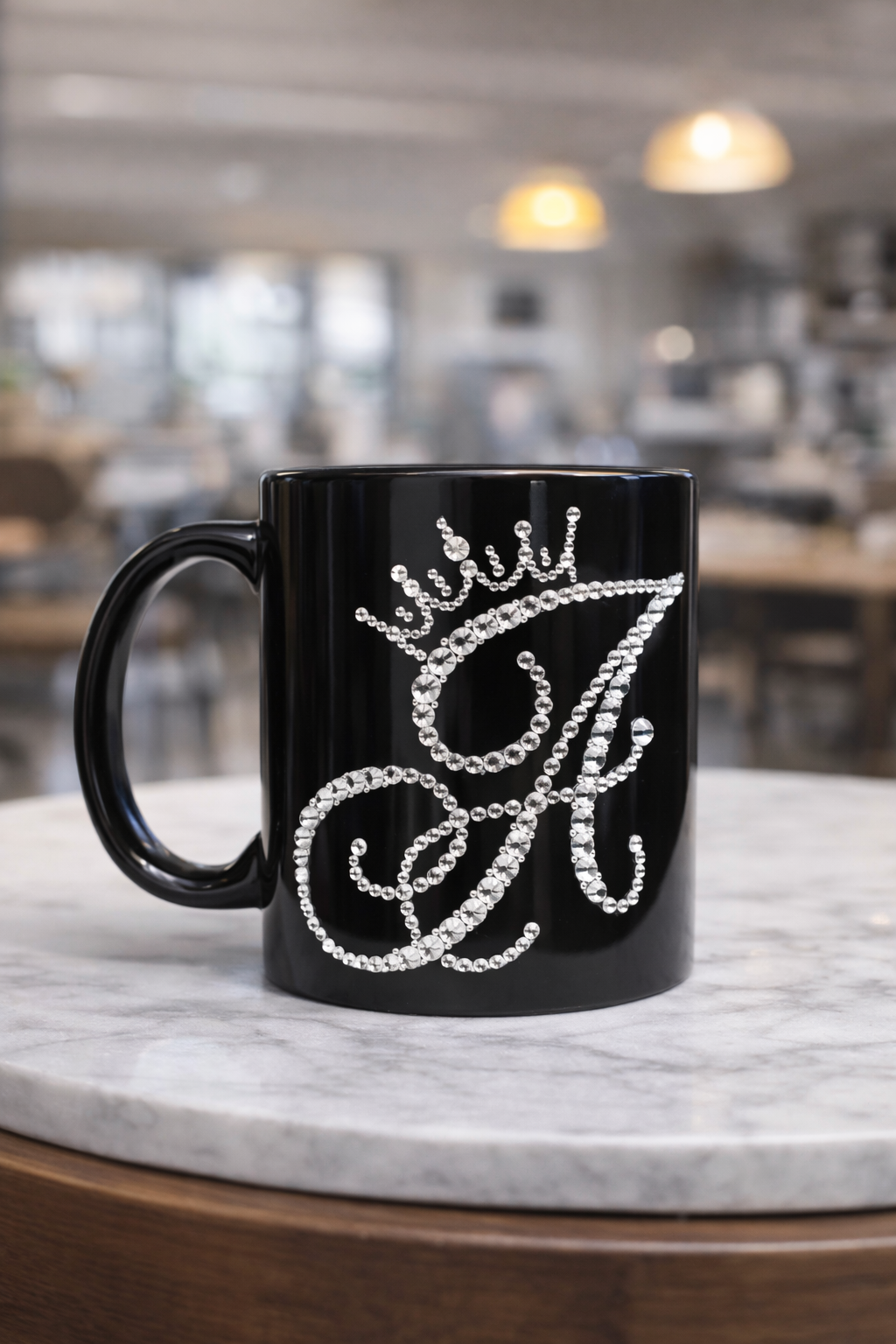Black mug with decorative letter 'A' design on a marble surface